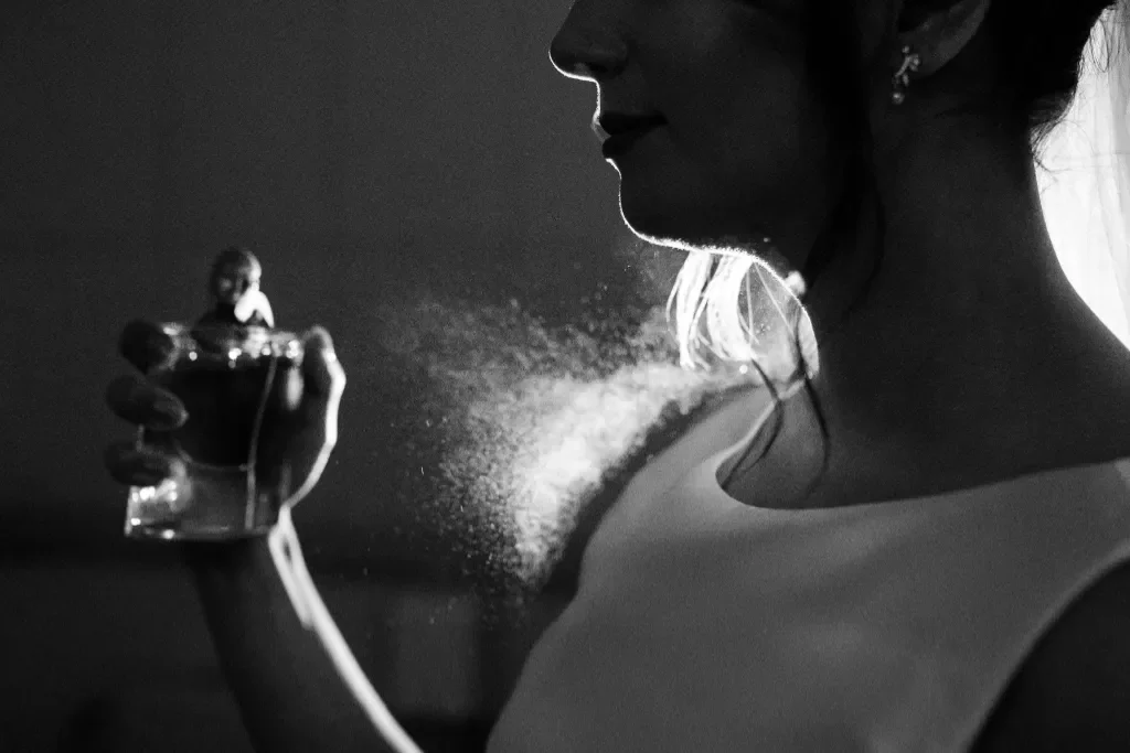 kobieta aplikująca perfumy